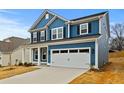 Charming two-story home featuring blue siding, black shutters, and a spacious two-car garage at 750 Opal Wing St, Moncks Corner, SC 29461