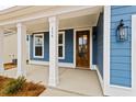 Inviting porch featuring white columns and a beautifully stained wood front door at 750 Opal Wing St, Moncks Corner, SC 29461