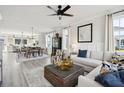 Bright, open-concept living room with hardwood floors, a ceiling fan, and views into the kitchen and dining area at 758 Blueway Ave, Summerville, SC 29486
