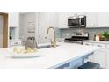 Bright kitchen features white cabinets, stainless steel appliances, and a stylish gold faucet at 1045 Northern Flicker Dr # Cc3-19-5P, Ravenel, SC 29470