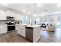 Open concept kitchen with island, stainless steel appliances, and view into the inviting living room at 1045 Northern Flicker Dr # Cc3-19-5P, Ravenel, SC 29470
