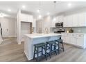 Modern kitchen with a large center island, white cabinets, and stylish bar stools for seating at 1045 Northern Flicker Dr # Cc3-19-5P, Ravenel, SC 29470