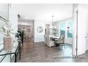 Bright dining area with wood floors, modern chandelier, and a view of the open-concept living spaces at 1050 Marsh Harrier Dr # Cc3-15-3P, Ravenel, SC 29470