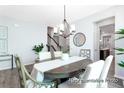 Elegant dining room with a statement chandelier, table setting, and views into other living spaces at 1050 Marsh Harrier Dr # Cc3-15-3P, Ravenel, SC 29470