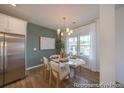 Bright dining room with a stylish chandelier, modern table setting, stainless steel refrigerator, and ample natural light at 1054 Marsh Harrier Dr # Cc3-15-5P, Ravenel, SC 29470