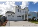 Beautiful new construction home with a spacious driveway, two-car garage and inviting front porch with chairs at 1054 Marsh Harrier Dr # Cc3-15-5P, Ravenel, SC 29470