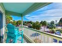 Balcony view with aqua chair overlooking palm trees, parking area and pier at 1300 Ocean Blvd # 232, Isle of Palms, SC 29451
