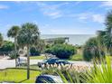 Scenic view with tropical landscaping of a parking area and the beach pier in the background at 1300 Ocean Blvd # 232, Isle of Palms, SC 29451