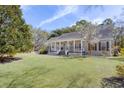 Lovely home featuring a covered front porch, well-maintained lawn, and lush landscaping for curb appeal at 1365 Whippoorwill Farm Rd, Johns Island, SC 29455