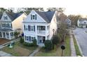 Aerial of a charming two-story home with a cozy front porch, complemented by a well-maintained yard at 1749 Towne St, Johns Island, SC 29455