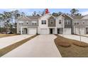 Charming townhomes featuring varied siding colors, attached garages, and concrete driveways lined by well manicured lawns at 205 Cozy Brook Ct, Summerville, SC 29486