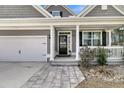 Inviting front porch with white columns, a black door, and a charming walkway at 225 Waning Way, Charleston, SC 29492