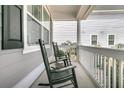 Cozy front porch with rocking chairs and white railings offering a relaxing outdoor space at 225 Waning Way, Charleston, SC 29492
