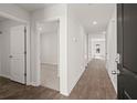 Bright hallway featuring wood-look floors and white doors, offering a welcoming and neutral space at 229 Coral Sunset Way, Summerville, SC 29486