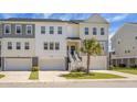 Inviting townhome featuring two-car garage, and welcoming front yard with a palm tree at 305 Lanyard St, Johns Island, SC 29455