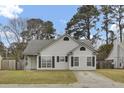 Inviting single-story home featuring neutral siding and black shutters enhancing its curb appeal at 4064 Bonaparte Dr, North Charleston, SC 29418