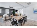 Open-concept dining area with modern black chairs, a wooden table, and seamless flow to the living room at 5034 Pittman St, North Charleston, SC 29405