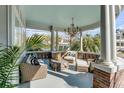 Inviting outdoor porch featuring comfortable wicker seating, a rustic wooden coffee table, and a stylish chandelier at 54 Gibbes St, Charleston, SC 29401
