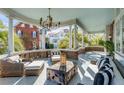 Inviting outdoor porch featuring comfortable seating, a rustic wooden coffee table, and a stylish chandelier at 54 Gibbes St, Charleston, SC 29401