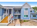 A bright blue condo building with stairs leading to the second floor and a sidewalk at 851 Sandlake Dr # F, Mount Pleasant, SC 29464