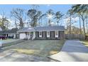 The brick home offers an attached garage, a well-manicured lawn, and a bright blue front door for added curb appeal at 105 Alan Ct, Summerville, SC 29485