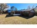 Backyard featuring a screened-in porch, brick facade, and lush greenery at 105 Ford Ct, Summerville, SC 29483