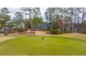 The back exterior of this home has a well-manicured lawn, golf course views, and ample space for outdoor activities at 105 Pine Valley Dr, Summerville, SC 29483