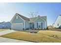 Charming home featuring light-blue siding, manicured lawn, and a neatly arranged front yard at 127 Garden Gate Way, Summerville, SC 29486