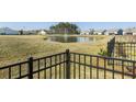 Scenic community pond with a fountain, visible from the backyard and framed by a black metal fence at 127 Garden Gate Way, Summerville, SC 29486