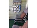 Balcony decor including a decorative wheel and anchor, along with comfortable chairs and a pillow at 1300 Ocean Blvd # 221, Isle of Palms, SC 29451