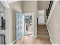 Bright foyer with an open blue door, hardwood floors, and a carpeted staircase at 15 Back Ct, Isle of Palms, SC 29451