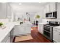 Modern kitchen featuring white cabinetry, quartz countertops, stainless steel appliances, and wood flooring at 158 Sandshell Dr, Charleston, SC 29492