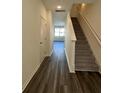 Inviting entryway featuring sleek wood floors, staircase with white railing, and abundant natural light at 1703 Scarlett Maple St, Summerville, SC 29486