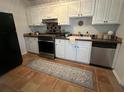 Classic kitchen features white cabinets, stainless steel appliances, and tiled floors at 21 Hester St # 2, Charleston, SC 29403