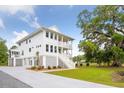 Exterior view of home with double porches, gray accents, and a long driveway leading to the property at 2151 Arthur Rose Ln, Johns Island, SC 29455