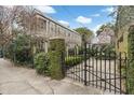 Classic gated entry showcases lush landscaping and a sidewalk view of a meticulously maintained home at 244 Ashley Ave, Charleston, SC 29403