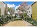 Inviting two-story home with landscaped yard, blooming tree, and chairs to enjoy the curb appeal at 244 Ashley Ave, Charleston, SC 29403