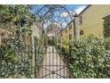Wrought-iron garden gate leads to a charming courtyard; the perfect welcome to an enchanting property at 244 Ashley Ave, Charleston, SC 29403