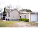 A cozy home exterior boasts a well-kept lawn and an attached garage for convenience at 2590 Otranto Rd, North Charleston, SC 29406