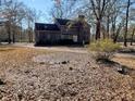 Back of brick house with mature landscaping and bare trees on a sunny day at 388 Benton Farm Rd, Walterboro, SC 29488