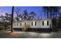 Charming single-story home featuring white siding, dark shutters, brick skirting, and wooden entry stairs at 421 Peacock Ln, Summerville, SC 29486