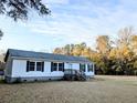 Well-kept single-story home boasting white siding, black shutters, and a spacious lawn at 5181 Dr Taylor Rd, Adams Run, SC 29426