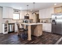 This kitchen features stainless steel appliances, white cabinets, an island and dark wood floors at 632 Dennis Ridge Rd, Bonneau, SC 29431