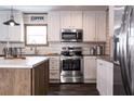 The kitchen features stainless steel appliances, white cabinets, an island, and dark wood floors at 632 Dennis Ridge Rd, Bonneau, SC 29431