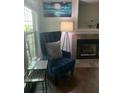 Cozy living room with blue armchair, side tables, fireplace, and soothing wall art at 700 Daniel Ellis Dr # 11202, Charleston, SC 29412
