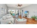Bright living room boasts hardwood floors, a ceiling fan, and a sliding door leading to the outdoor space at 106 Sea Lavender Ln, Summerville, SC 29486