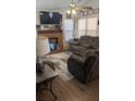 Cozy living room with a brick fireplace, plush seating, and a ceiling fan at 107 Ranworth Ln, Summerville, SC 29485