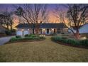 Beautiful one-story brick home with a manicured lawn and lush, landscaped garden at 110 Dunbury Dr, Summerville, SC 29485