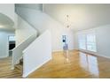 Bright living room featuring hardwood floors, modern chandelier, and staircase access at 112 Mansfield Blvd, North Charleston, SC 29418