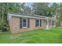 Side view of a single-story brick house with black shutters and green lawn at 112 Pine Grove Dr, North Charleston, SC 29420
